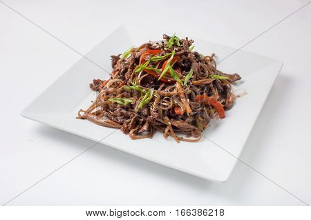Soba Buckwheat noodles with chicken teriyaki on a white background