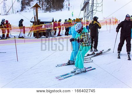 SLOVAKIA, STRBSKE PLESO - JANUARY 06, 2015: Skiers and other active people in Strbske Pleso. The village is a favorite ski tourist and health resort in the slovakian part of High Tatras mountains.