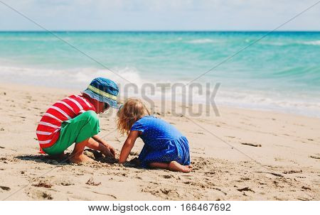 kids play with sand on summer beach, family beach vacation