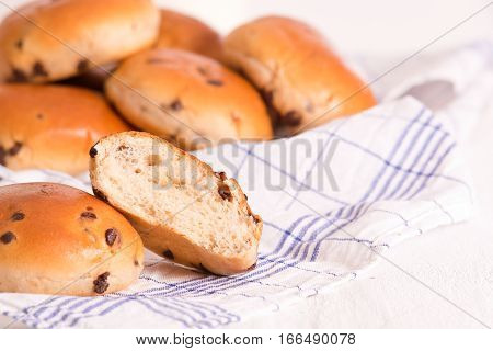 Chocolate chip brioche bun on wooden table.