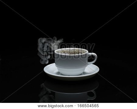 warm cup of coffee with smoke on black background