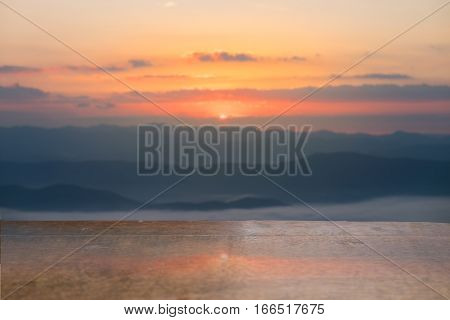 Selective foucus on Empty wooden table with the sunrise mountain view background. For display or montage your products.