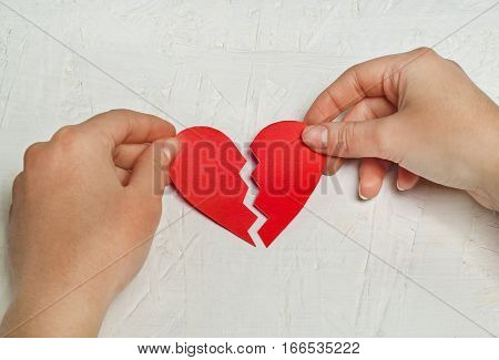 Close up of paper broken heart on white wooden background