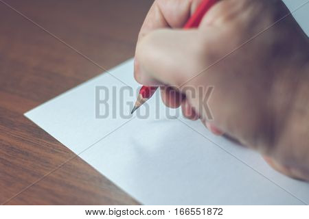 A Close Photo Of A Persons Writing A Letter With A Pencil