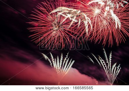 Colorful fireworks displays at night relfecting on the water