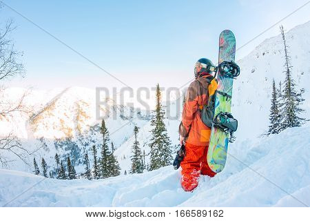 Freerider Man Is Standing On The Mountainside In A Helmet And With A Backpack And Looks Into The Dis
