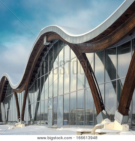 MINSK BELARUS - January 15 2017: Sports complex Olympic reserve. Pool National Olympic Training Center in athletics in Minsk Belarus. Element of modern building with circular shape facade against blue clear sky. 