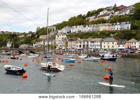 LOOE, CORNWALL, UK - MAY 17, 2015: Looe fishing port with paddle surf practice