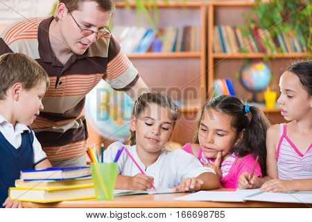 Portrait Of Diligent Schoolkids And Their Teacher