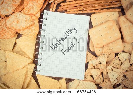 Vintage Photo, Inscription Unhealthy Food In Notebook And Heap Of Crisps And Cookies