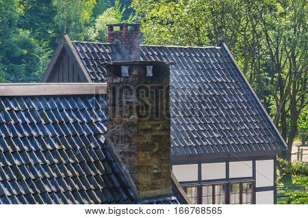 Smoking chimney on the roof of a house.