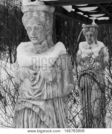 Sculpture Of A Caryatids In Winter Park Covered With Snow.