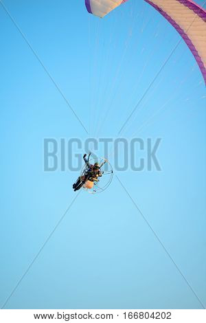 adventure man active extreme sport pilot flying in sky with paramotor engine glider parachute