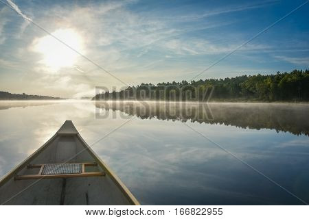 Canoe trip in the morning.  Brilliant and bright mid-summer sunshine morning, paddling a canoe in the middle of quiet, calm and peaceful Corry lake.