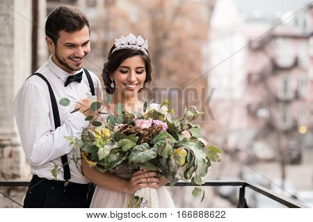 The bride and groom embrace on the balcony. Couple hugging on the balcony and enjoy life