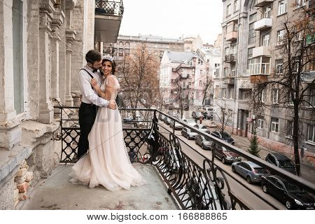 The bride and groom embrace on the balcony. Couple hugging on the balcony and enjoy life