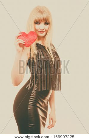 People in love happiness. Young lady with red heart. Beautiful blonde woman holding ticker. Attractive girl has make up and black outfit.