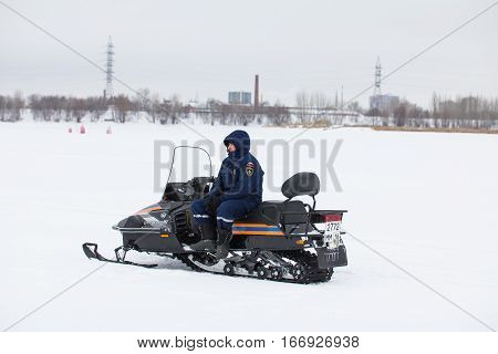 KAZAN, RUSSIA - JANUARY 19, 2017: Russian MoE lifeguard with snowmobile - rescuer on ice at winter day during Christ's baptism holiday , telephoto