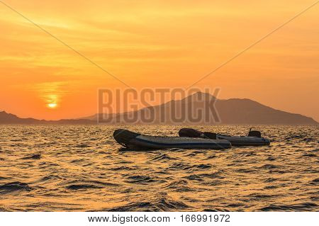 Boats against the rising over the island the Tyrant sun.