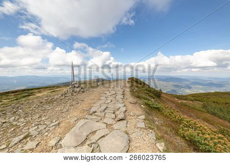 Hiking trail to Mala Babia Gora Mountain from Przelecz Brona Pass in Polish Beskid. High mountains landscape under blue sky with clouds.
