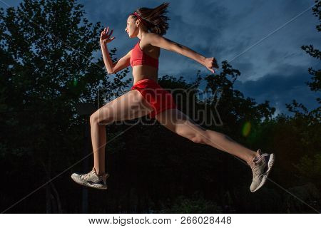 Young Happy Woman Running Outdoor In A City Park. Girl Running Running In The Nature To Lose Weight 