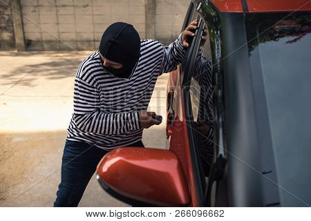 Car Thief Trying To Breaking A Car's Windows To Steal A Woman Bag