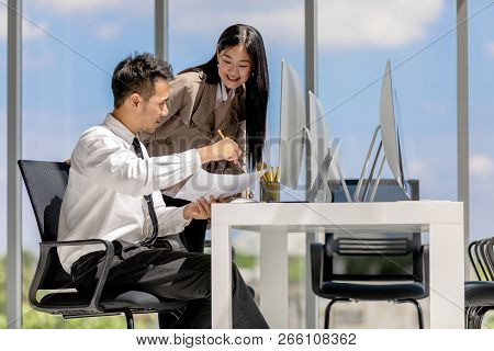 Young Asian Businessmen Are Working Together In A Modern Office. There Are Many Modern Computers Pla