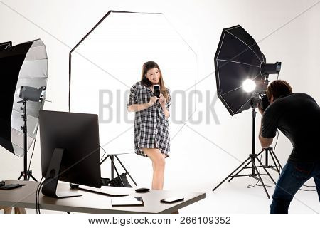 Photographer And Model Working In Modern Lighting Studio With Many Kinds Of Flash And Accessories.