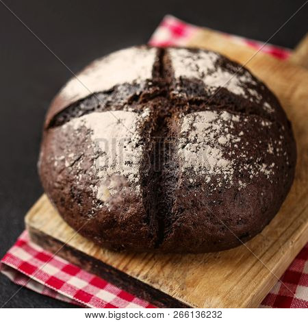 Fresh Bread On Black Chalkboard Background. Top View With Copy Space. Rye Bread On Cutting Board Clo