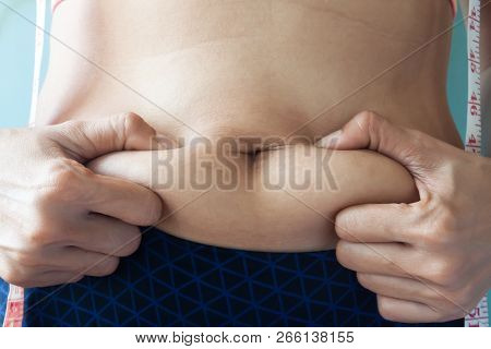 Getting Rid Of Belly Fat, Diet, Weight Loss Or Gain Concept. Woman Squeezing Belly
