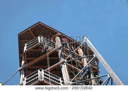 People Learining Safely The Technic Of Climbing On A Wooden Building. Saftey, Worker, Danger, Climbi