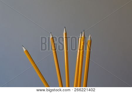 A Bunch Of Simple Pencils. The Color Of The Pencils Is Orange And The Background Is Gray. There Is A