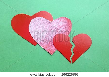 Broken Hearts Made Of Cardboard And Paper On A Green Background Symbol Of Infrequent Love Separation
