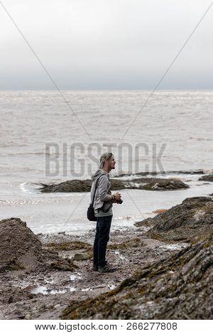 Hopewell Rocks, New Brunswick, September 17, 2018 - Horizontal View Of A Young Man Taking Pictures O