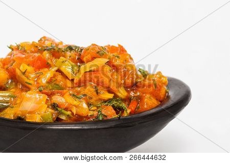 Traditional Colombian Sauce Called Hogao Served In A Black Ceramic Dish Isolated On White Background