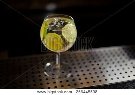 View From Above On The Gin Tonic Cocktail Decorated With Lime Slices Standing On The Steel Bar Count