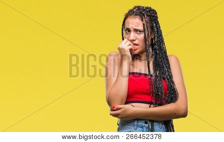 Young braided hair african american with pigmentation blemish birth mark over isolated background looking stressed and nervous with hands on mouth biting nails. Anxiety problem.