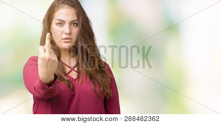 Beautiful plus size young woman over isolated background Showing middle finger, impolite and rude fuck off expression