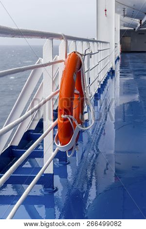 Bright Lifebuoy With Light Hanging On The Ship On A Cloudy Day Against The Open Sea.