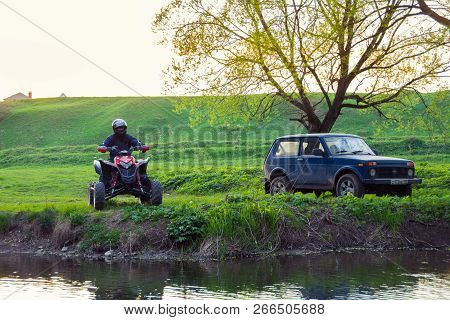 Moscow, Russia - May 17, 2014: Atv Rider In The Action On Honda Trx700xx (and Parked Lada Niva)