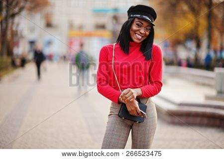 African American Fashion Girl In Newsboy Cap And Handbag Posed At Street.