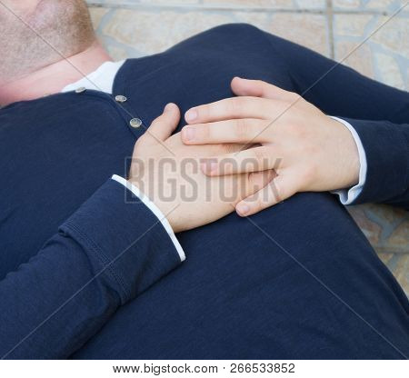 Man With A Heart Attack Lies On The Ground.