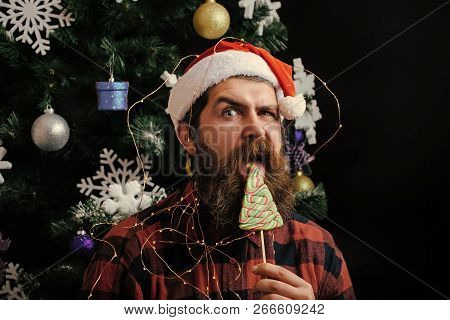 Christmas Man With Beard On Surprised Face And Lollipop. New Year Guy Lick Candy Or Sweet. Santa Cla