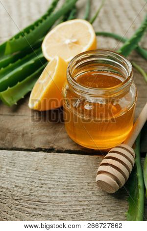 Honey In A Glass Jar, Lemon And Aloe Vera On Vintage Wooden Background. Alternative Medicine Closeup