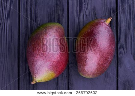 Two Organic Mango On Wooden Background. Close Up Whole Fresh Mango On Black Wooden Boards.