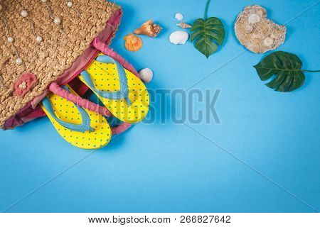 Yellow Sandals With Woven Handbags On Blue Color Background, Summer Holidays Accessories . Flat Lay 