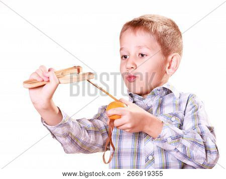 Nature And Free Time Prankster Little Boy. Child Have Fun With  Wooden Sling Shot And Fruit Aim Mand