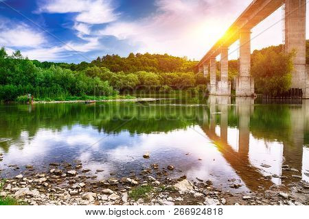 Huge Arch  Bridge Built Over Dnister River In Ukraine. Beautiful Clouds In The Sky Over The River In
