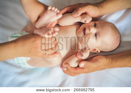 Because Care Begins In Family. Newborn Baby Given Massage By Parents. Newborn Baby Care. Happy Paren