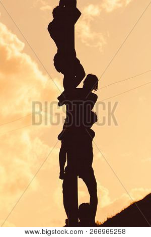 Silhouette Burmese Man Climbing Pole On End Of Buddha Day